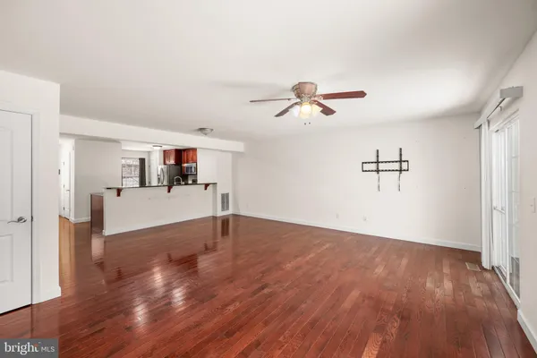 a view of a livingroom with wooden floor and a ceiling fan