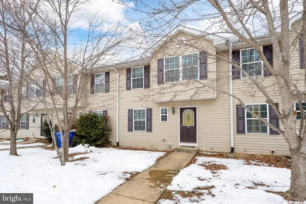 a backyard of a house with a barbeque and large trees