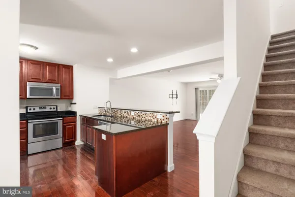 a open kitchen with stainless steel appliances granite countertop a stove and a refrigerator