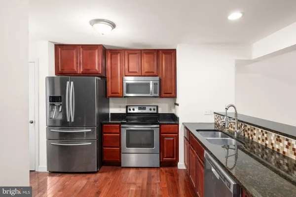 a kitchen with stainless steel appliances granite countertop a refrigerator stove and sink