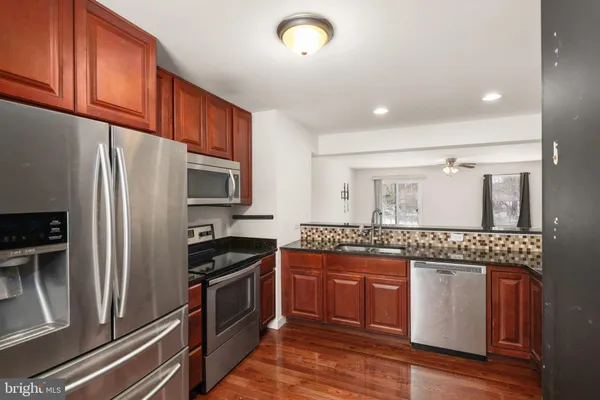 a kitchen with granite countertop stainless steel appliances and wooden cabinets