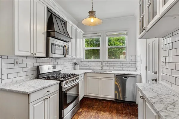 a kitchen with stainless steel appliances granite countertop a stove a sink and a microwave