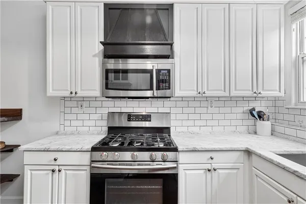 a kitchen with microwave a stove and cabinets