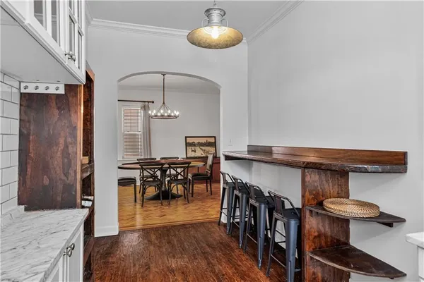 a kitchen with stainless steel appliances granite countertop a stove top oven a dining table and chairs with wooden floor