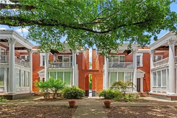 front view of a brick house with a large windows and a large tree
