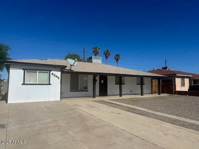 a view of a white house with a big yard and large trees