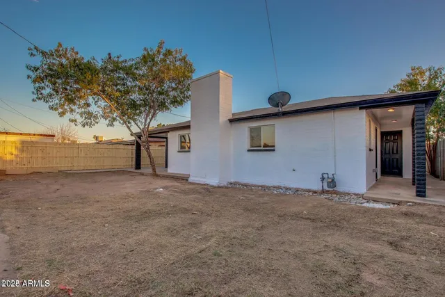 a view of a house with a tree and a yard