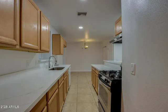 a kitchen with stainless steel appliances granite countertop a sink a stove and a refrigerator