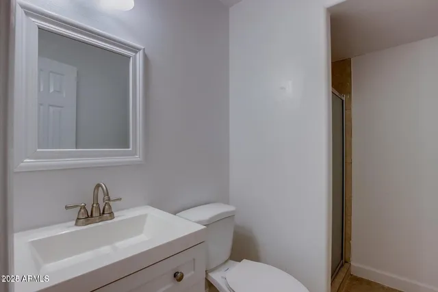 a bathroom with a sink mirror and toilet