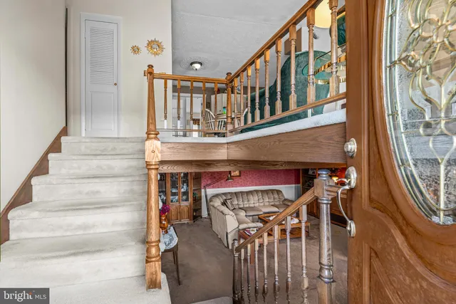 a living room with furniture a clock on wall and a flat screen tv
