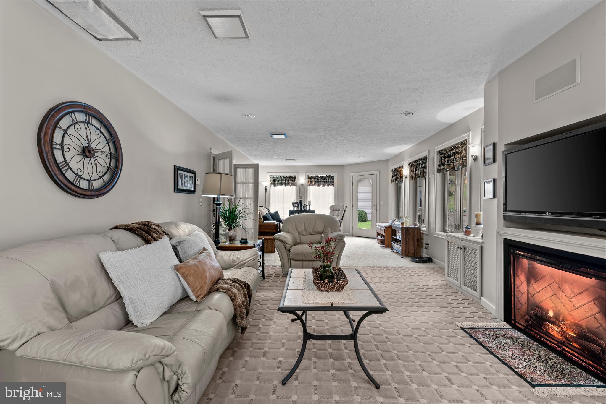 125 Housel Road Hopewell, PA 16650 - Photo 58 of 105 a living room with furniture a clock on wall and a flat screen tv