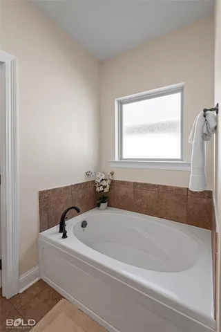 a bathroom with a bathtub and a window
