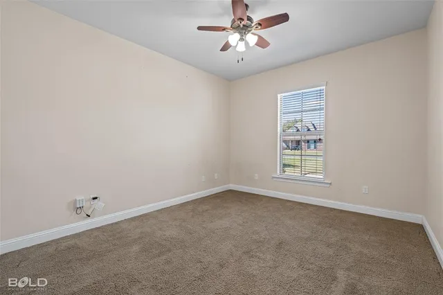 an empty room with a window and a fan