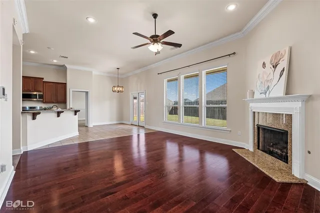 a view of a livingroom with wooden floor and a kitchen