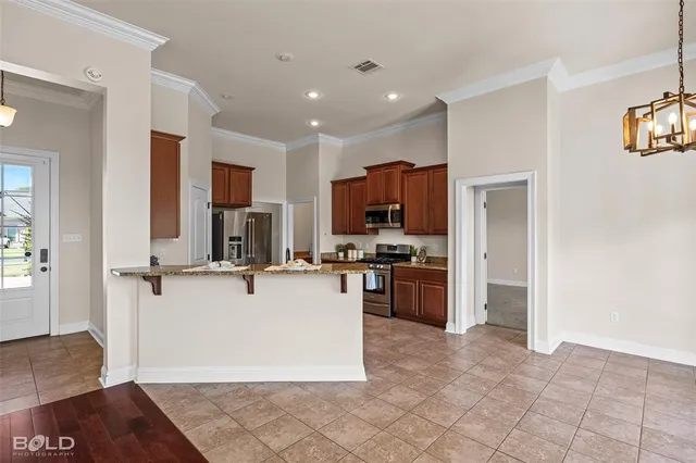 a view of kitchen with refrigerator stove microwave and cabinets