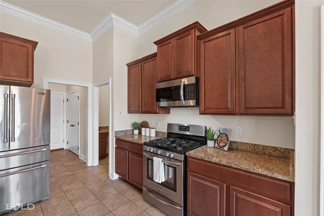 a kitchen with stainless steel appliances granite countertop a refrigerator a stove a sink and a microwave