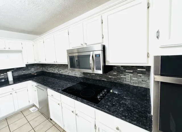 a view of a livingroom with a flat screen tv wooden floor and a ceiling fan
