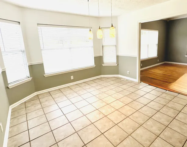 a kitchen with granite countertop white cabinets and black appliances
