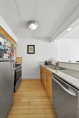 a large kitchen with stainless steel appliances granite countertop a sink and cabinets