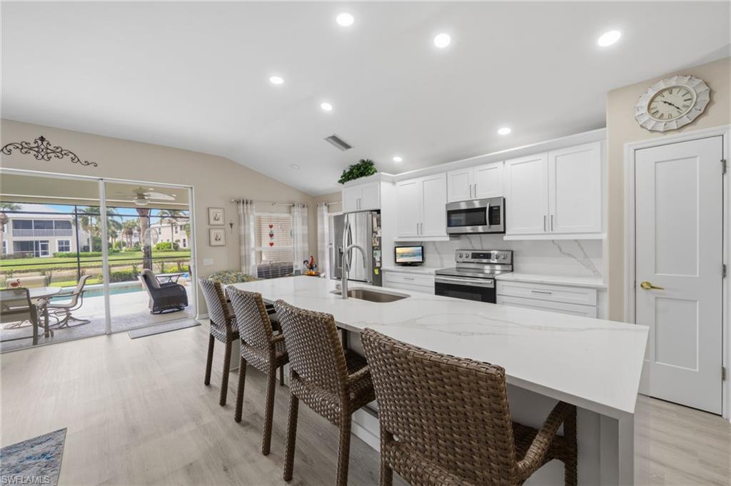 10020 Horse Creek Road Fort Myers, FL 33913 - Photo 15 of 31 a kitchen with stainless steel appliances a dining table chairs and a refrigerator