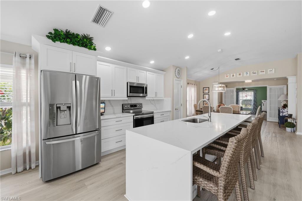 10020 Horse Creek Road Fort Myers, FL 33913 - Photo 10 of 31 a kitchen with stainless steel appliances a refrigerator and a stove top oven