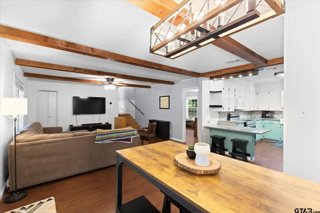 a living room with kitchen island furniture and a flat screen tv