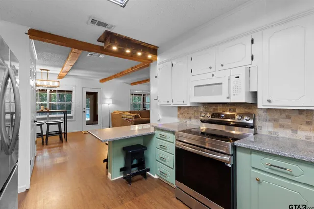 a kitchen with stainless steel appliances granite countertop a stove and a refrigerator