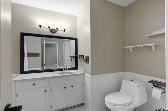 a bathroom with a toilet a sink and mirror