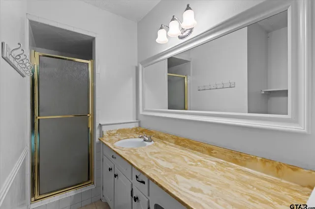 a bathroom with a granite countertop sink and a mirror