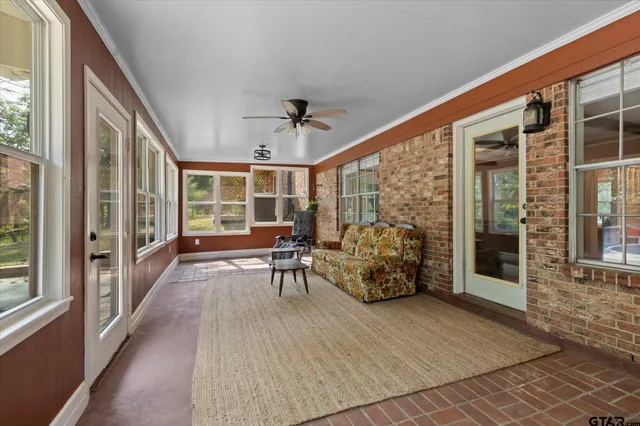 a view of a porch with chairs and floor to ceiling window