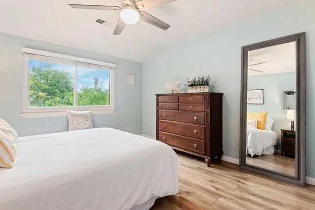 a bedroom with a bed and a mirror on the dresser