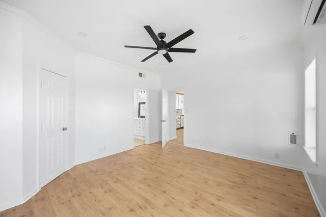 a view of a big room with wooden floor and windows
