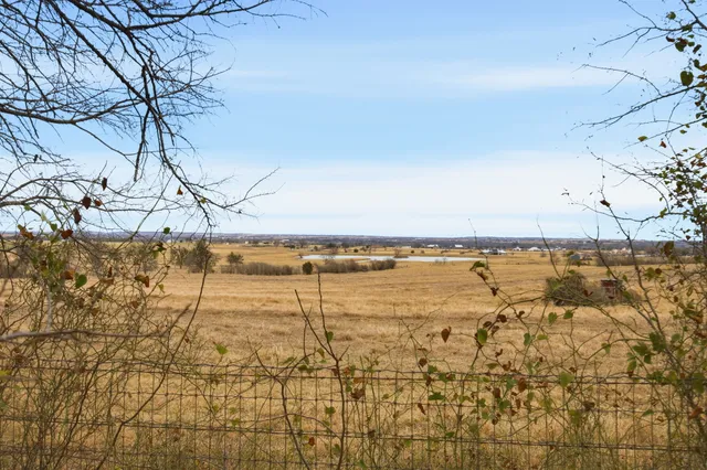 a front view of a house with a yard and lake view