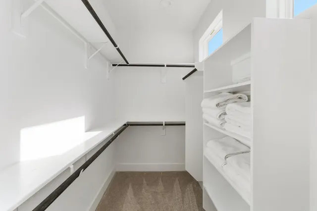 a view of walk in closet with empty racks