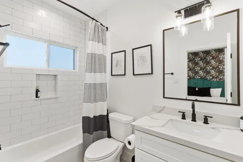 a bathroom with a sink a toilet and shower