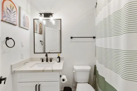 a bathroom with a sink vanity mirror and toilet
