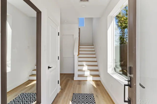 a view of a hallway with wooden floor and windows