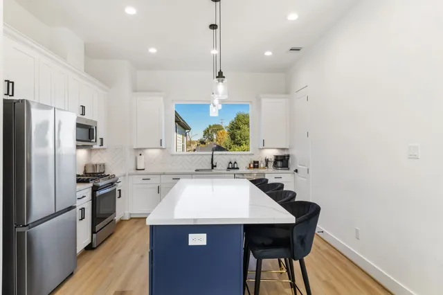 a kitchen with a sink a counter top space stainless steel appliances and cabinets