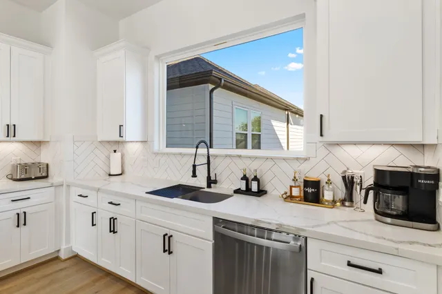 a kitchen with white cabinets and white appliances