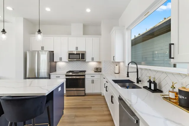 a kitchen with stainless steel appliances granite countertop a sink stove and refrigerator