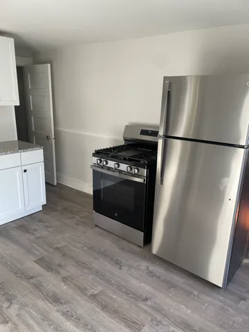 a kitchen with a stove refrigerator and microwave