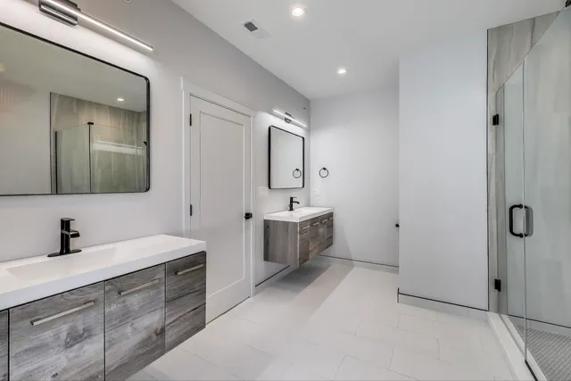 a spacious bathroom with a double vanity sink mirror and bathtub