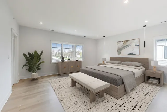 a spacious bedroom with a large bed and a potted plant