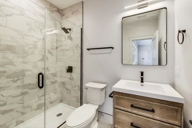 a bathroom with a sink a toilet and shower