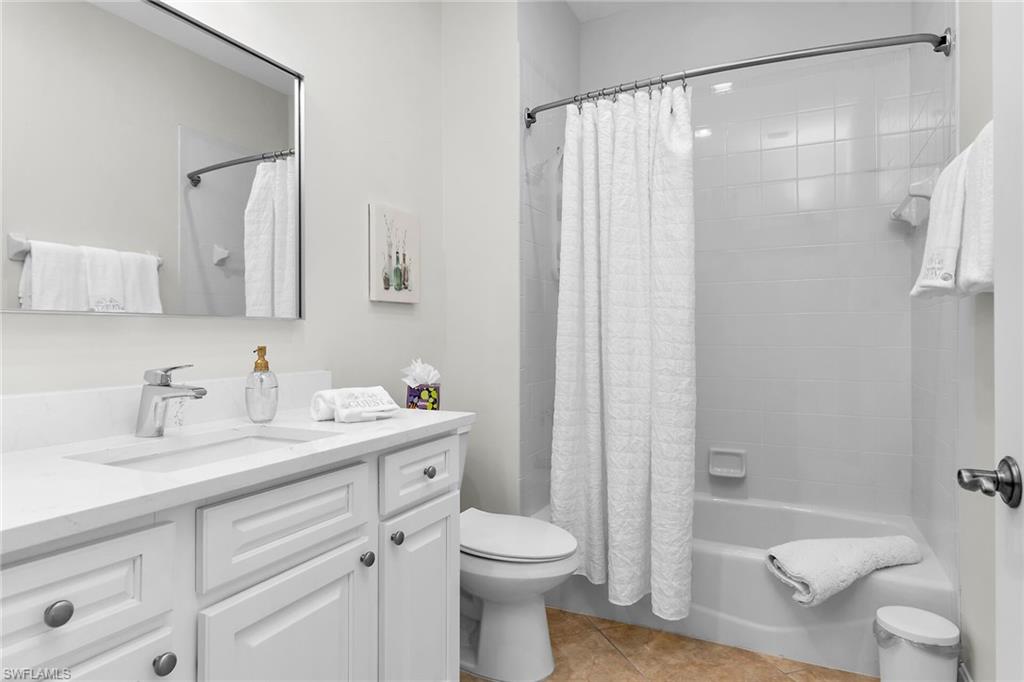 1286 Rialto Way, Unit 9202 Naples, FL 34114 - Photo 22 of 49 Bathroom with tub and shower combination, single vanity with updated cabinetry, new white quartz countertops, tile flooring, and recessed lighting.