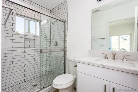 a bathroom with a toilet sink vanity and mirror