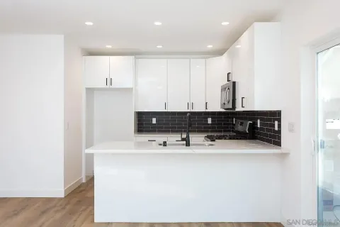 a kitchen with kitchen island stainless steel appliances a sink and cabinets