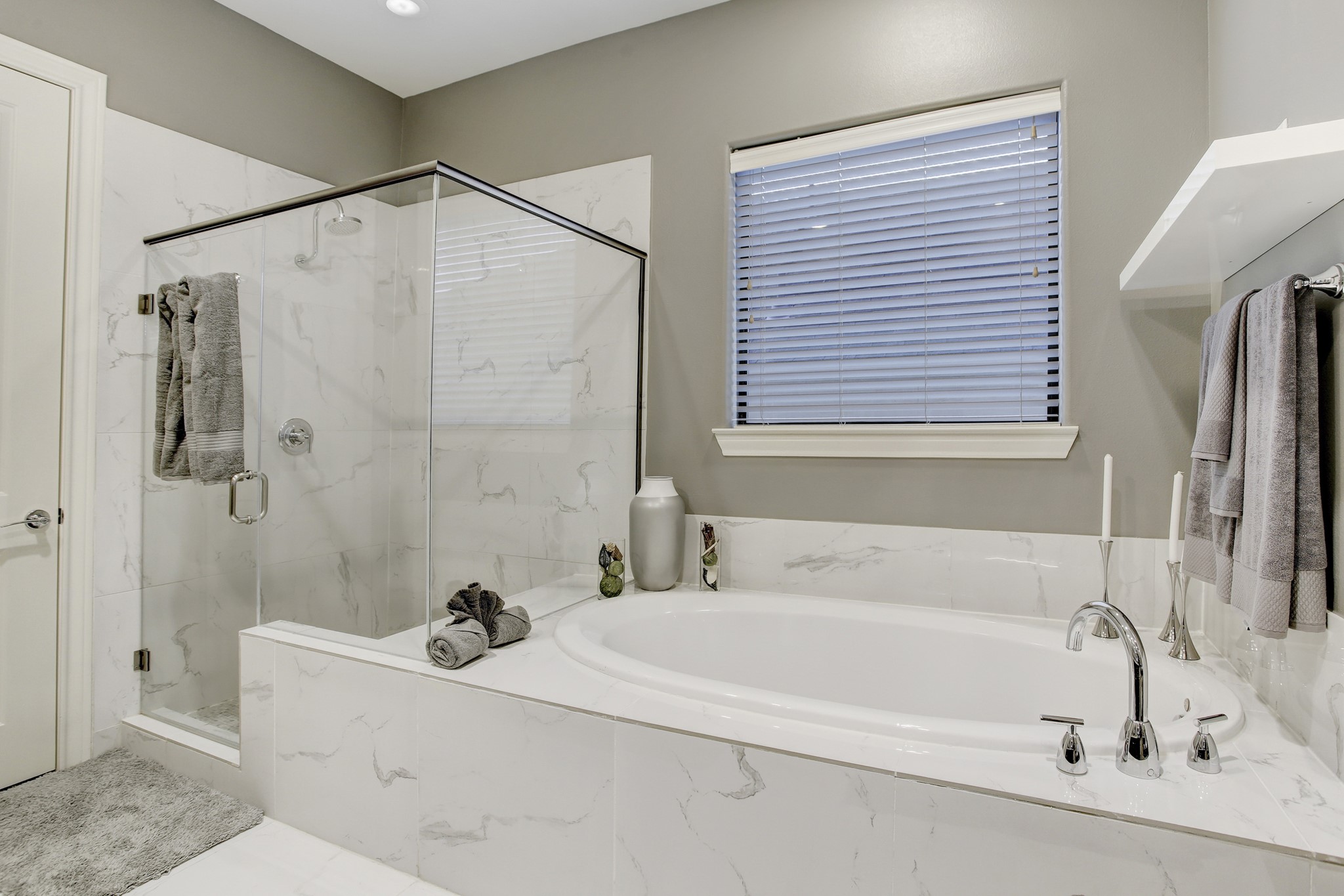 5506 Darling Street Houston, TX 77007 - Photo 13 of 23 The deep soaking tub in the Primary Bath has a gorgeous marble surround and a window above for natural light, and the walk-in shower features a beautiful glass surround and is clad in marble.