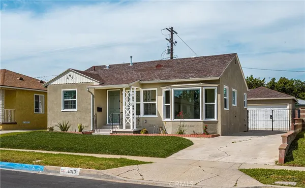 a front view of a house with a garden and plants