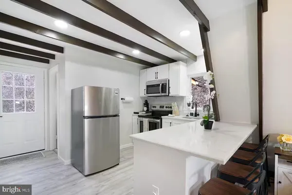 a kitchen with a refrigerator a stove a microwave and cabinets